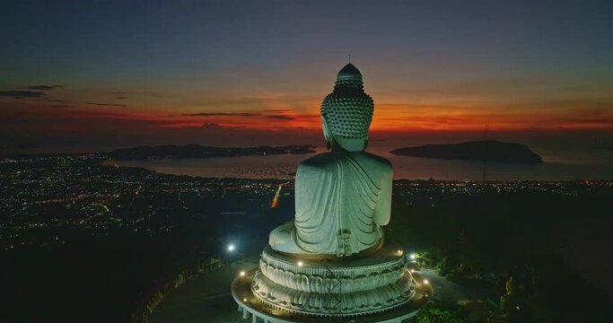 aerial view stunning red light in twilight in front of Phuket big Buddha..The sun's rays illuminate the Buddha's serene making it .stand out against the backdrop of sky and creating a stunning image