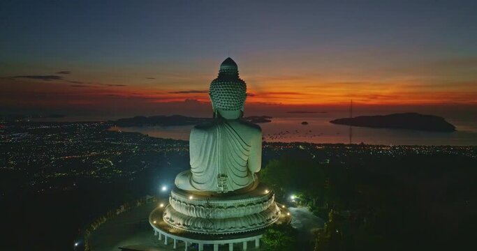 aerial view stunning red light in twilight in front of Phuket big Buddha..The sun's rays illuminate the Buddha's serene making it .stand out against the backdrop of sky and creating a stunning image