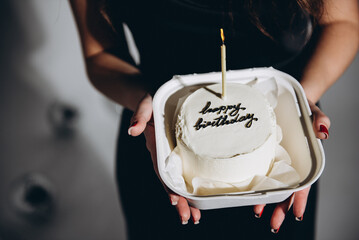 The person is holding a bento cake.  Birthday cake. Young beautiful girl holding a birthday cake