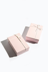 Obraz premium Two pale pink gift boxes on a white background. Top view, flat lay