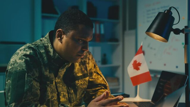 Upset military officer of Canada working in office, problems with a war mission