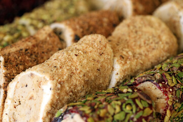Rolls of turkish delight with many different flavors and fillings close up on table of vendors market bazaar