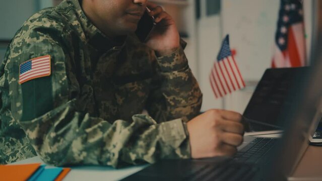 African American army officer talking on phone in office, controlling operation