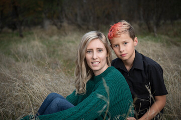 Smiling blonde mother son outdoor autumn portrait with trendy two tone hair dye 