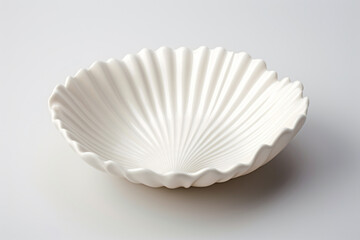 a white bowl with a large shell shaped design