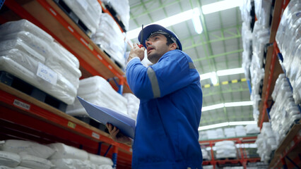 Worker using walkie talkies to communicate with coworkers during checking inventory of a manufacturing company at Plastic factory.