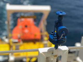 closeup view of valve with free fall life boat in the back ground