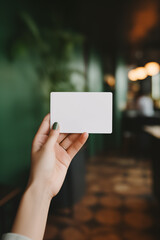 female hand holding a blank business card