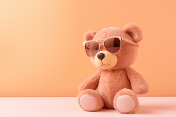 A plush teddy bear in trendy sunglasses, framed by a peach color and soft pink pastel background, creating a perfect blend of fun and style for children's decor.