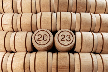 Year 2023 on wooden barrels. The number 2023 among a pile of small wooden kegs