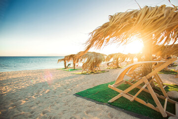 Sun umbrellas and sunbeds on sandy beach. Travel and holiday concept