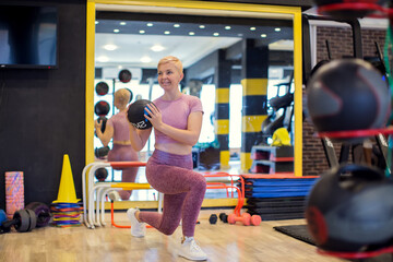 Woman exercising with medicine ball at gym. Fitness and health concept
