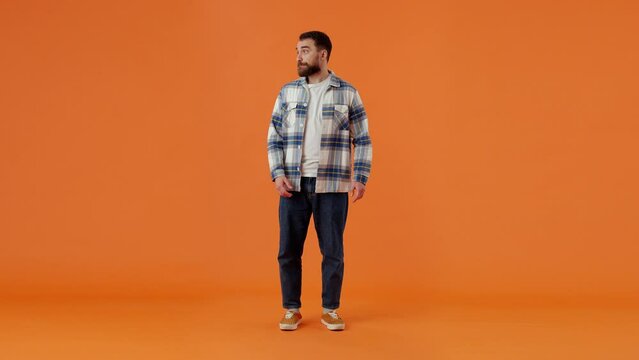 Confused bearded man shrugging with shoulders and looking at camera