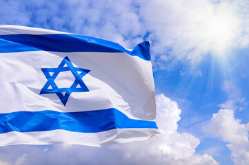 Israel flag with a star of David over cloudy sky background. - 697314041