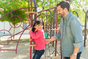 Obraz premium Attractive dad with his young child on the playground