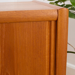 Late-Century teak credenza. Vintage wooden sideboard. Indoor detail photograph. 