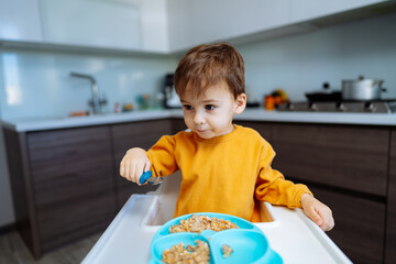 A Curious Little Boy Discovering the Joy of a Colorful Meal. A little boy sitting at a table with a...