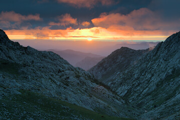 Sunset in the mountains with orange clouds