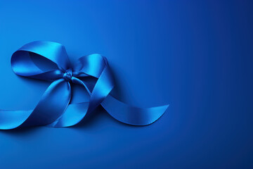 A striking dark blue ribbon on a blue background , raise awareness of colon cancer awareness . - obrazy, fototapety, plakaty