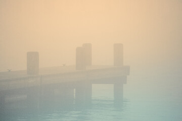 Nantucket Harbor Fog Seascape on an autumn morning with pastel toned silhouette of the dock in Massachusetts, United States, an abstract minimalist backgrounds for mysterious or moody themes