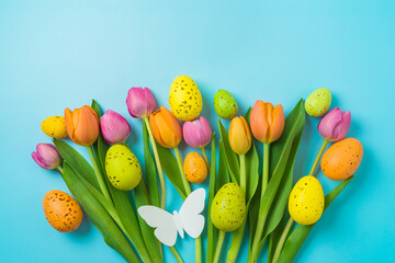 Easter holiday background with easter eggs and tulip flowers. Top view, flat lay