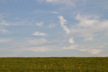 Sanfte Hügel und Weideland unter dem weiten Himmel einer ländlichen Idylle 