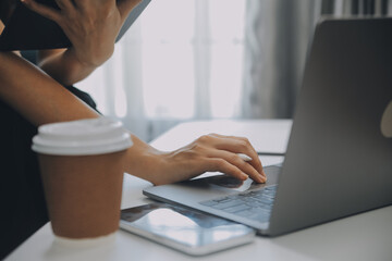 Asian Businesswoman Using laptop computer and working at office with calculator document on desk,...