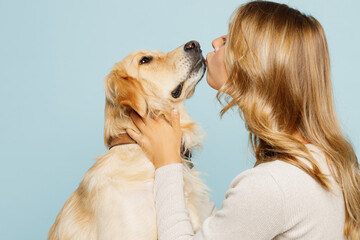 Side profile view young owner woman with her best friend retriever wear casual clothes kiss hug...