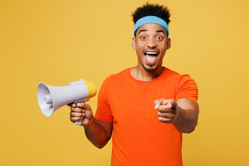 Young fitness trainer sporty man sportsman wear orange t-shirt scream in megaphone point finger...