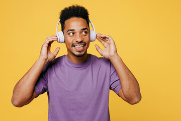 Young man of African American ethnicity he wearing purple t-shirt casual clothes listen to music in...