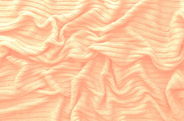 Texture of smooth knitted sweater with pattern. Handmade knitting wool or cotton fabric texture. Background of Large knit pattern with knitting needle or crochet. Peach Fuzz colour of 2024 year