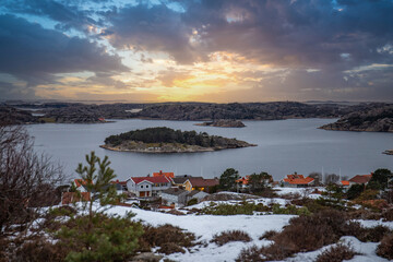 View over a stony coastal landscape in winter. Snow, ice and withered heather. Landscape shot in the town of Fjällbacka on the west coast of Sweden - obrazy, fototapety, plakaty