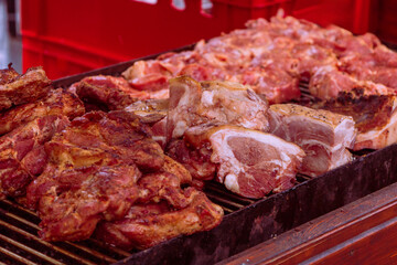Food in a large round pan and grill placed on the counter and intended for sale in the market to customers.