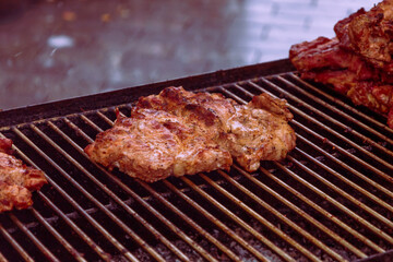 Food in a large round pan and grill placed on the counter and intended for sale in the market to customers.
