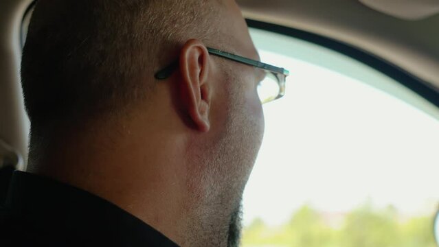 Portrait tired man driving car and yawns, wants to sleep and opens his mouth wide. Traveling by highway in countryside, handsome guy in SUV
