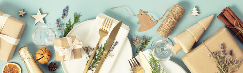 Christmas table place setting on blue background flat lay banner
