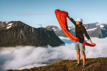 Man pulling sleeping bag out of its cover hiking camping gear active travel vacations in mountains...