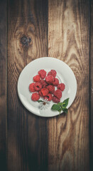 Red raspberries lie on a plate, raspberries for dessert