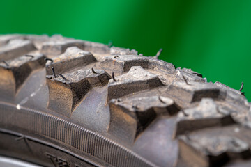 detail of a black bicycle tire with fur on the surface. green background.