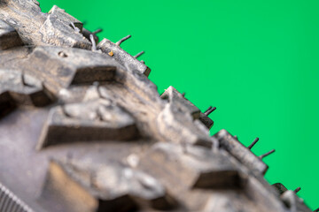 detail of a black bicycle tire with fur on the surface. green background.