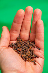 food cloves in palm under green background