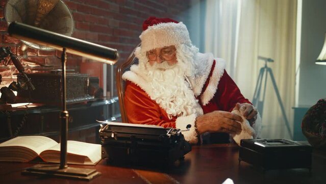 Santa taking off his gloves sitting in his workshop after successfully handing out presents