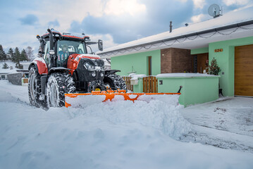 The snow plow tractor while clearing snow on the street - obrazy, fototapety, plakaty