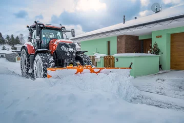 Crédence de cuisine en verre imprimé Tracteur The snow plow tractor while clearing snow on the street