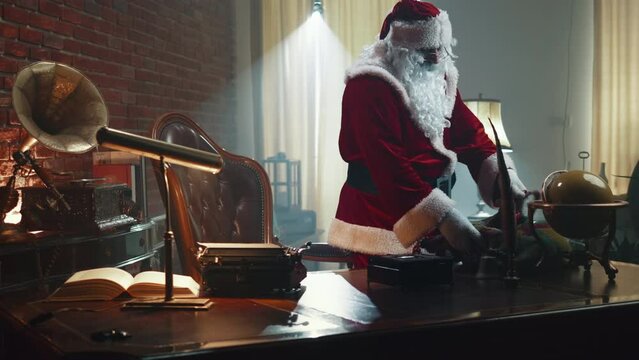 Santa Claus enters his workshop after handing out presents, feels tired, sits on a chair and stretches