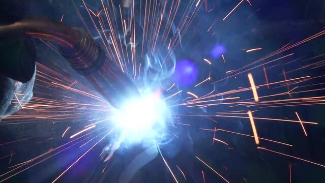 Close-up of a welder at a factory making metal structures. Welding torch equipment tool during metal welding works
