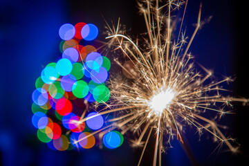 Sylvester New Year, New Year's Eve 2024 party event celebration holiday greeting card - Closeup of sparkling sparklers and bokeh lights in the background © Adrian