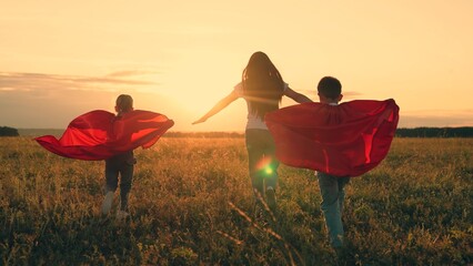 Mom, Super kids dream of becoming superhero, flying in red cape. Mother daughter, son play...