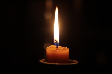 burning candle on black