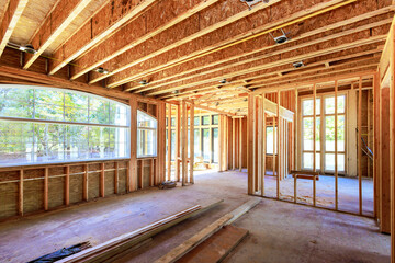 New home is being built at building area with unfinished framing beams wooden home in construction...